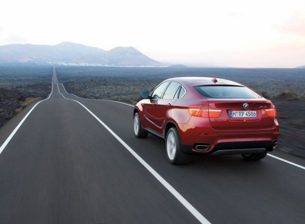 Der BMW X6 aus der Heckansicht: unterwegs in weiter Landschaft. 