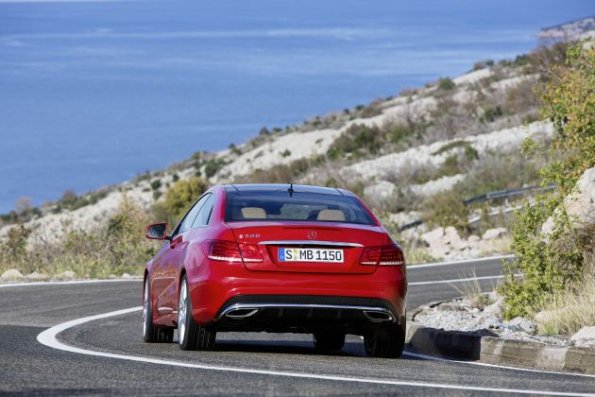 Die Fahraufnahme zeigt die Heckpartie des Mercedes-Benz E 500 Coupé mit AMG Sportpaket, (C 207), 2012, Lack: feueropal, Ausstattung: Leder Nappa schwarz/ porzellan